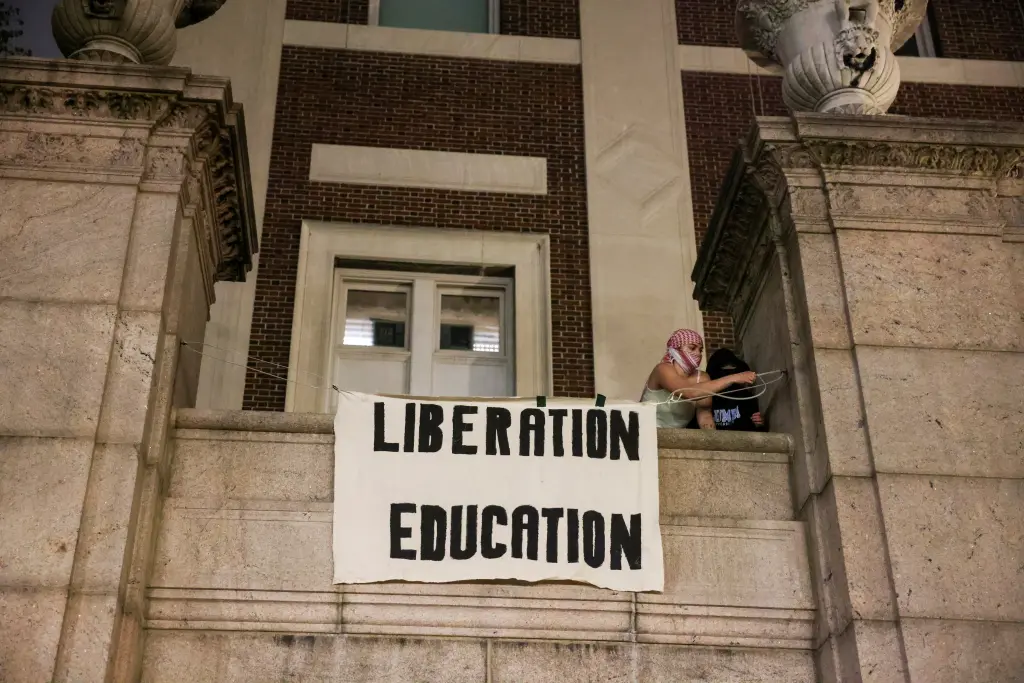 Protesters hang banners on the exterior of the Hamilton Hall building after barricading themselves inside the building at Columbia University.