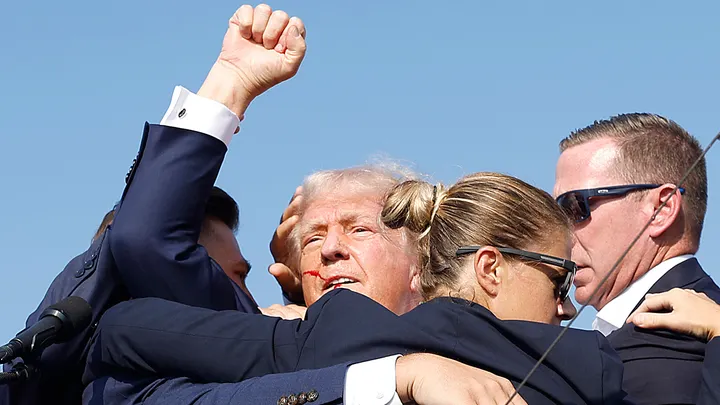 Republican presidential candidate former President Donald Trump raises his arm as he is rushed offstage by Secret Service in Butler